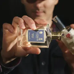 Mężczyzna trzyma perfumy Floris Special No 127. W składzie może być benzoesan benzylu, nadający zapachowi głębi.