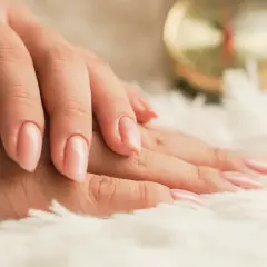 Delikatne, różowe, modne paznokcie na miękkim, białym tle.